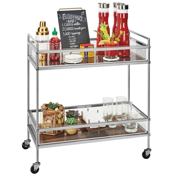 A Cal-Mil chrome beverage cart with walnut shelves holding a variety of items.