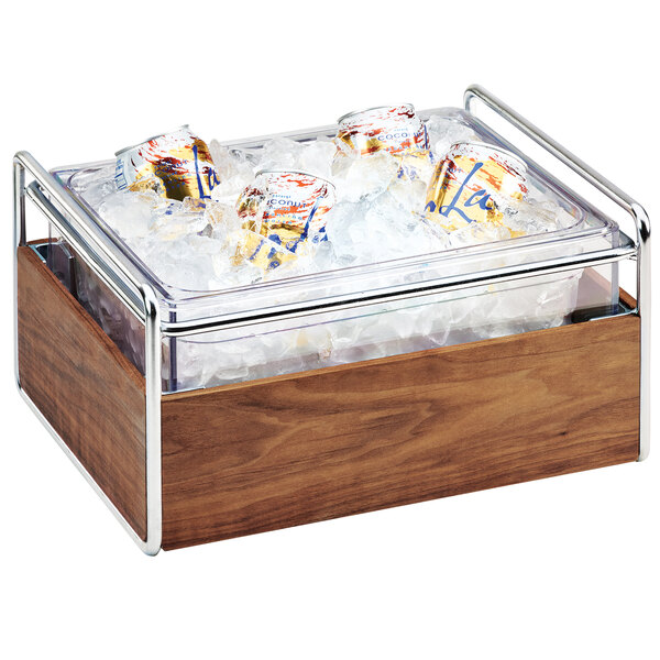 A Cal-Mil wooden ice housing container with ice and cans inside.