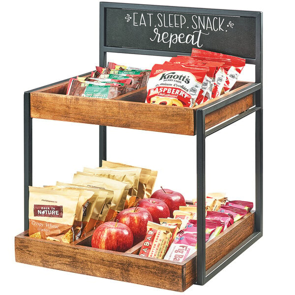 A Cal-Mil two tier wooden merchandiser with snacks on the shelves and a chalkboard sign.