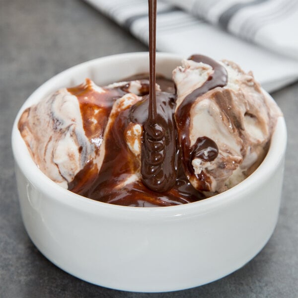 A bowl of ice cream topped with Hershey's chocolate sauce.