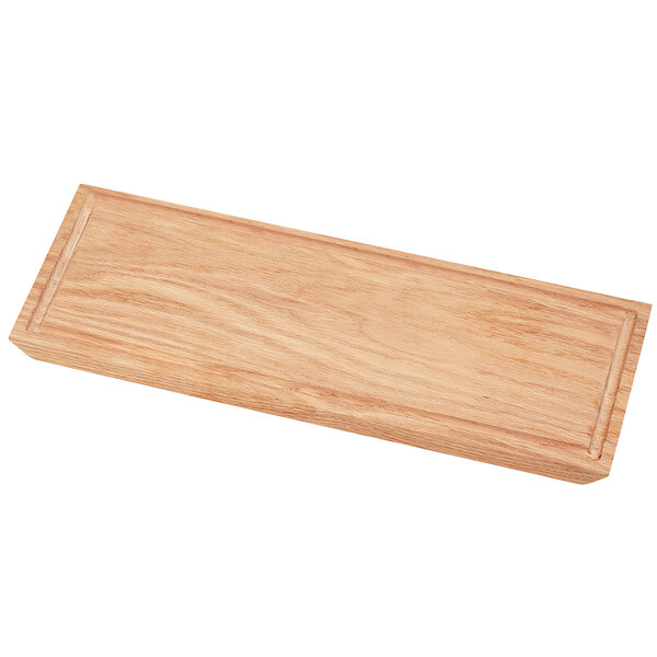 A Cal-Mil oak rectangular serving board with a carved edge and a handle.