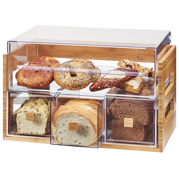 A Cal-Mil bamboo bread display case with bread and pastries inside.