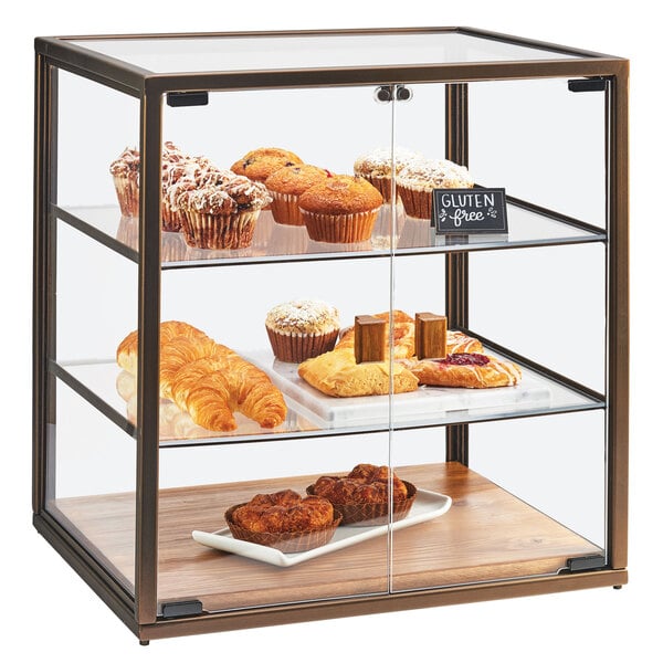 A Cal-Mil vintage bakery display case with muffins on the top shelf.
