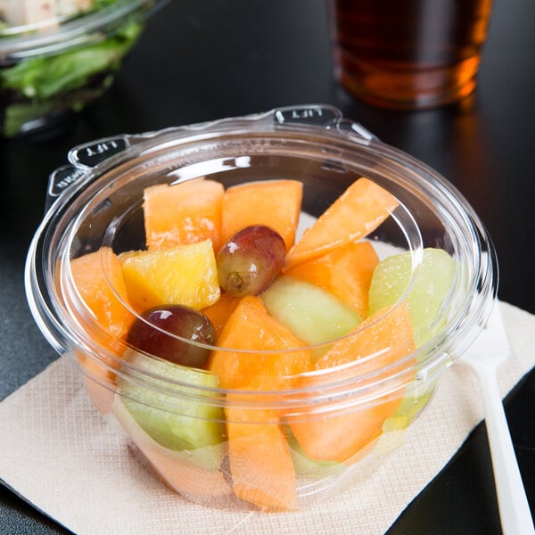 A Dart plastic bowl of fruit salad with a flat lid.