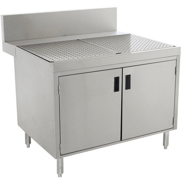 A stainless steel Advance Tabco drainboard cabinet with doors and a shelf over a stainless steel sink.