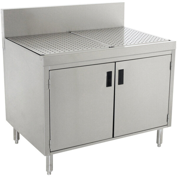 A stainless steel Advance Tabco drainboard cabinet with doors over a stainless steel sink.