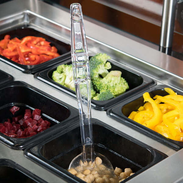 A clear plastic Cambro salad bar spoon in a container of food.