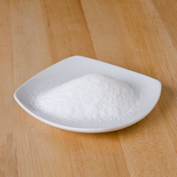 A white plate with a pile of Morton non-iodized table salt on it.
