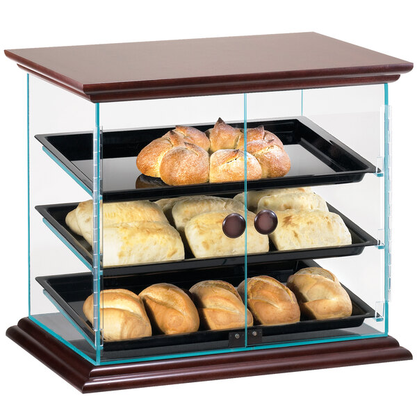 A Cal-Mil Westport wood display case with bread and pastries on the shelves.