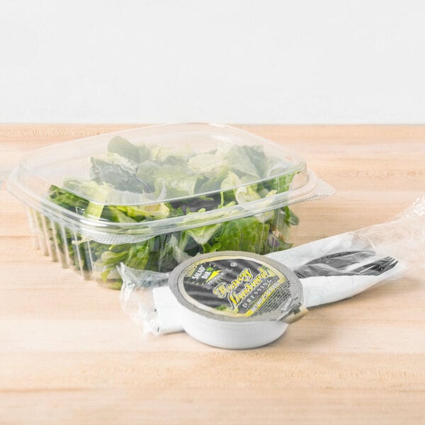 A clear plastic Genpak deli container of lettuce.