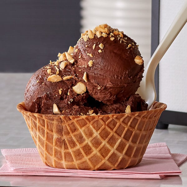 A JOY waffle bowl filled with chocolate ice cream with nuts.