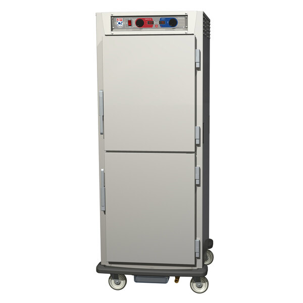 A white Metro C5 heated holding / proofing cabinet with two solid doors on wheels.