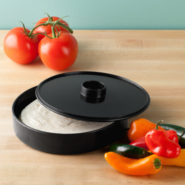 A black HS Inc. polypropylene tortilla server with tomatoes and peppers on it.