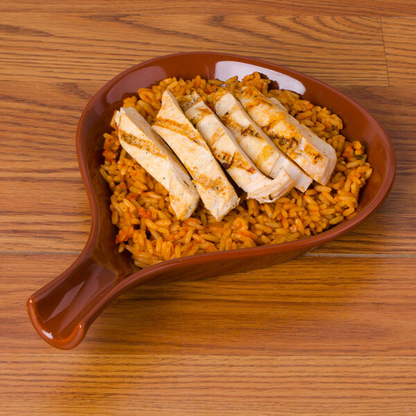A CAC brown fry pan plate with rice and chicken.