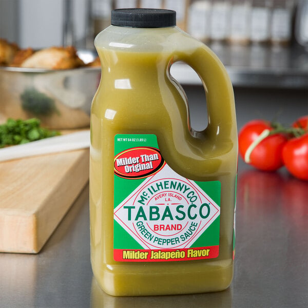 A bottle of TABASCO Green Pepper Hot Sauce on a counter with a label.