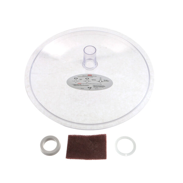 A clear plastic lid with a round piece of rubber.