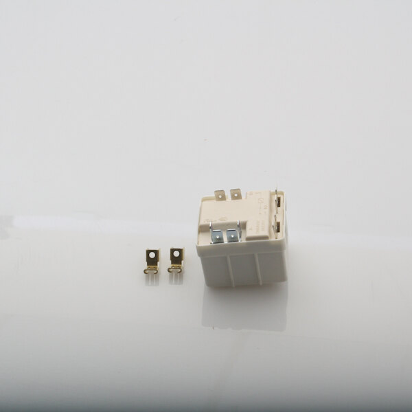 A white square Manitowoc Ice start relay with metal connectors.