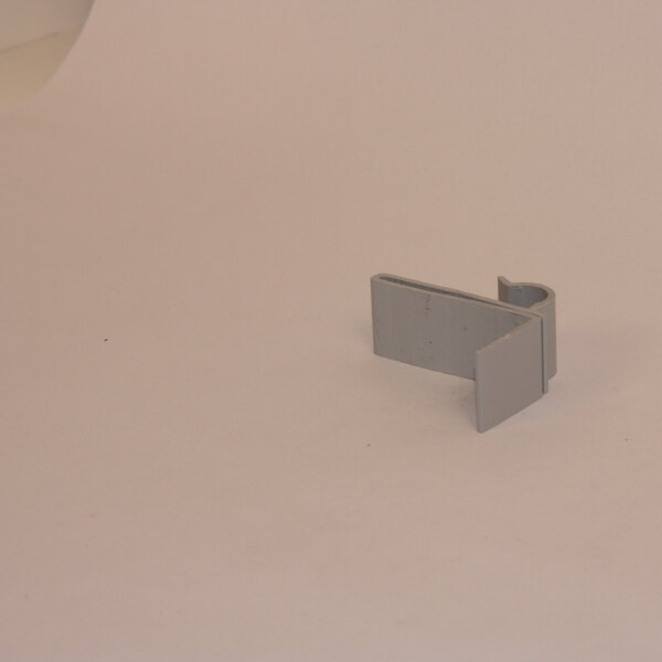 A grey plastic clip on a white surface.