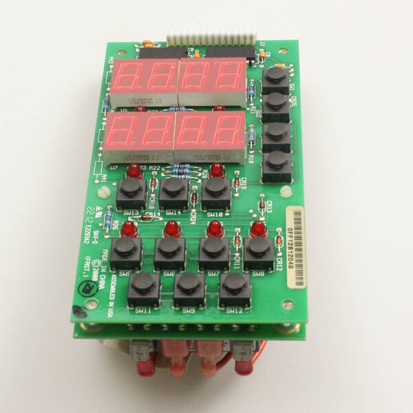 A green circuit board with black buttons and red and green lights.