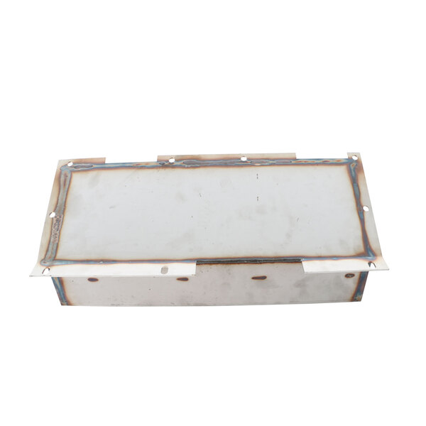 A metal plate with a white rectangular object and holes.