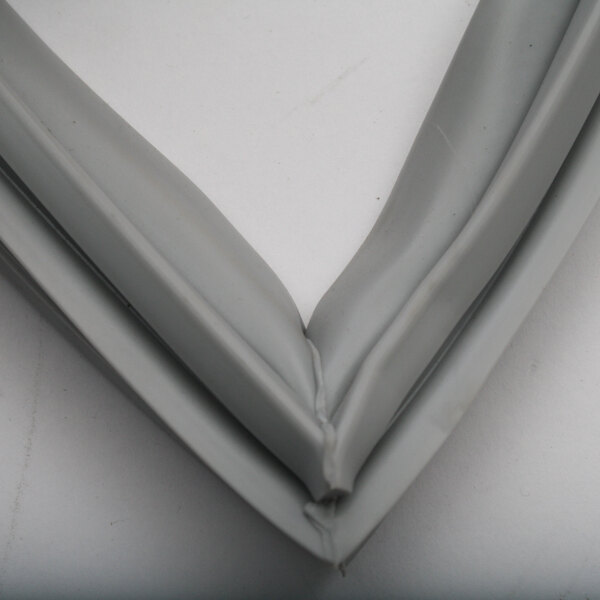 A close-up of a grey plastic and rubber corner on a Delfield Xing Xing full door refrigeration gasket.