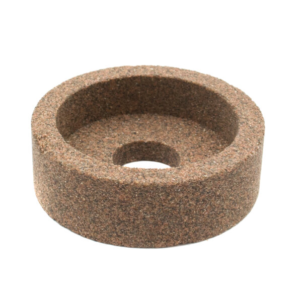 A brown circular grinding stone with a hole in the middle.