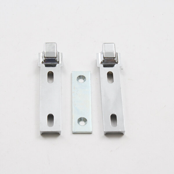 Two Kason metal latch strikes on a white rectangular object with a hole in it.