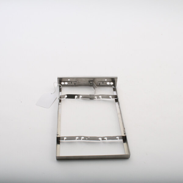 A metal frame with a metal tag and holes, holding a metal plate with a small metal plate attached.
