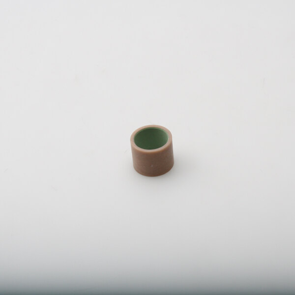 A small brown ceramic cup with a green center on a white surface.