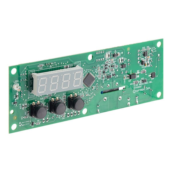 A green circuit board with black knobs and a digital display.