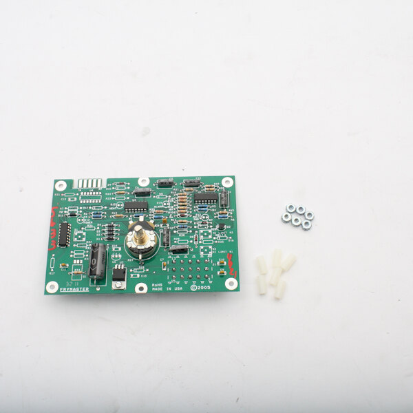 A green circuit board with small white objects and a small screw.
