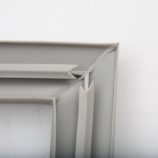 A close up of a grey plastic corner on a Delfield MCC17910 drawer gasket.