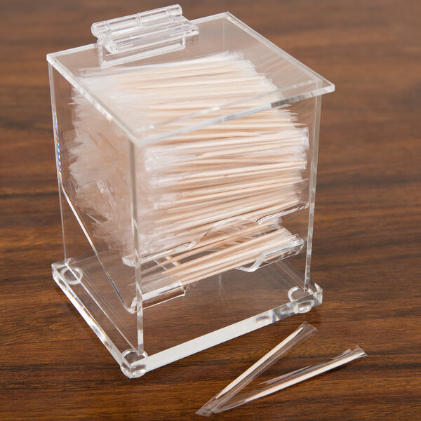 A clear plastic Cal-Mil toothpick dispenser filled with toothpicks on a counter.