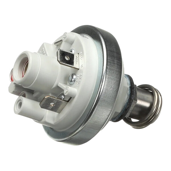 A round white and silver pressure switch with metal parts and a red knob.