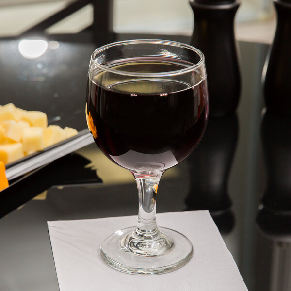 A Libbey red wine glass filled with red wine on a table.