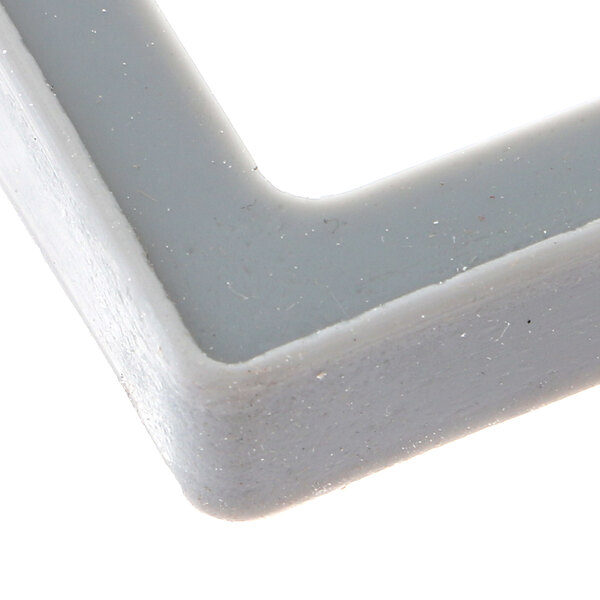 A close up of a square white plastic Henny Penny lid gasket.