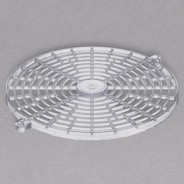 A plastic circular fan guard with a grid of holes.