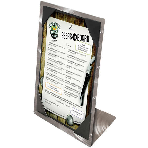 An Alumitique aluminum table tent with swirl picture corners holding a beer menu on a table in a brewery tasting room.