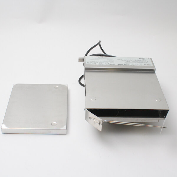 A silver rectangular metal box with a black wire and a small metal plate.