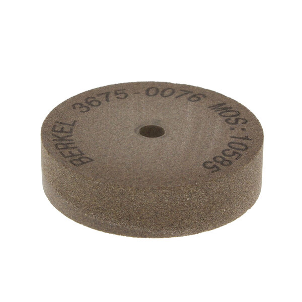 A brown Berkel grinding wheel with a hole in the middle.