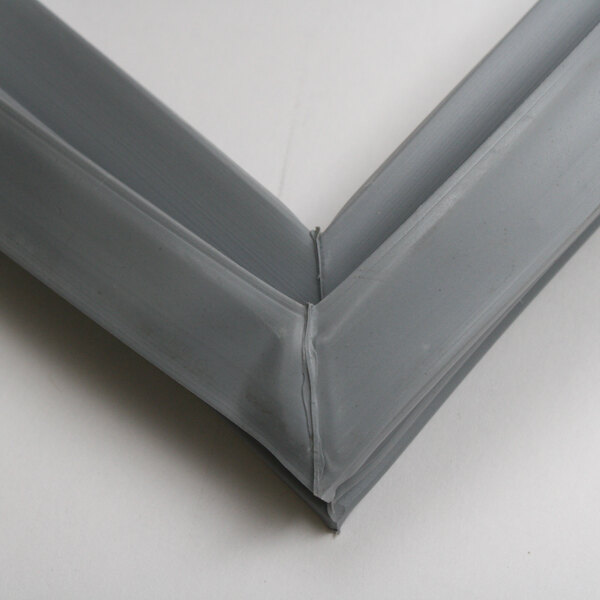 A close up of a corner of a grey rubber seal on a metal frame.