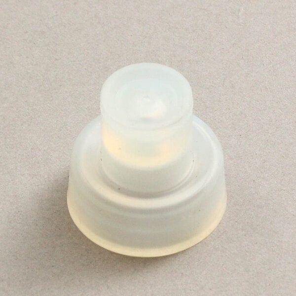 A white plastic Grindmaster-Cecilware faucet seat with a round top.