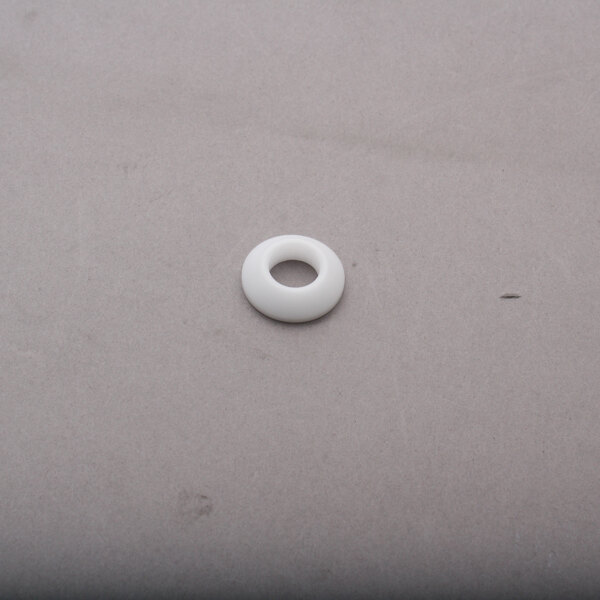 A white plastic round bearing with a hole in the center.