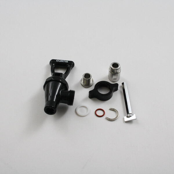 A black plastic and silver Wilbur Curtis faucet valve and other parts on a white surface.