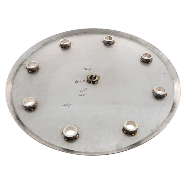 A metal circular plate with holes and screws on it.