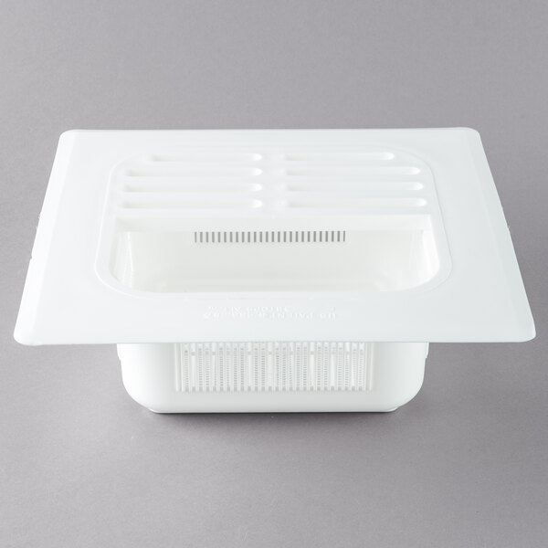 A white plastic FMP floor sink strainer with rows of lines and a vent.