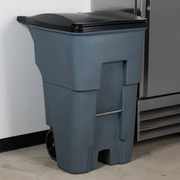A Rubbermaid 95 gallon gray rectangular trash can with black lid.