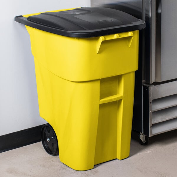 A yellow Rubbermaid commercial trash can with wheels and a black lid.