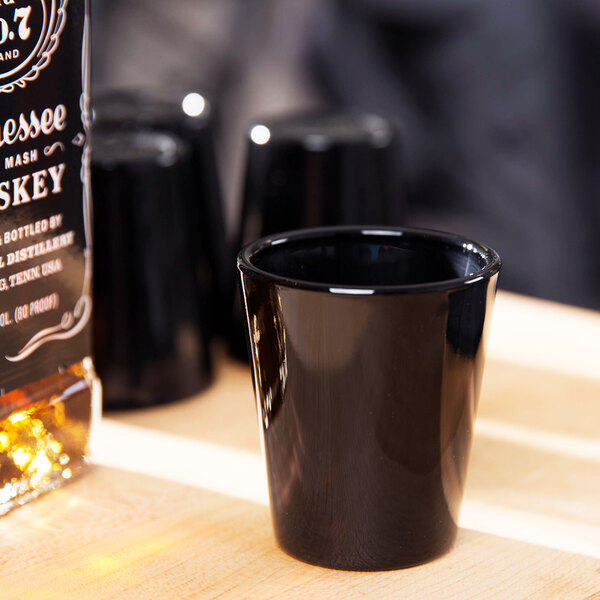 A black Libbey shot glass on a table.