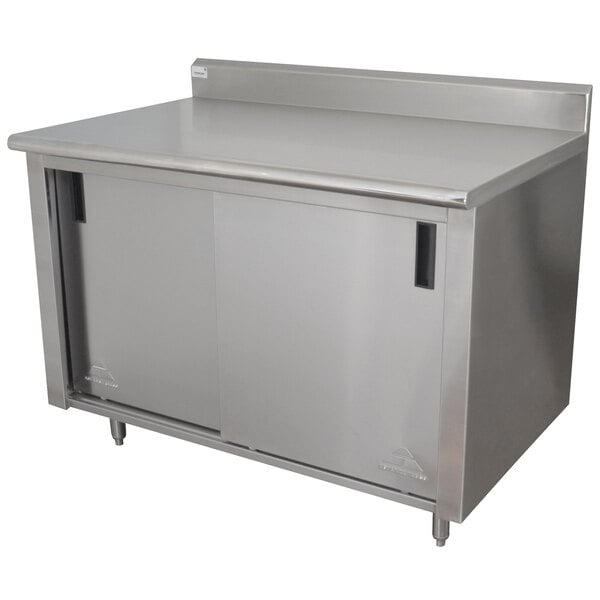 A stainless steel cabinet with doors and a shelf beneath a stainless steel work counter.